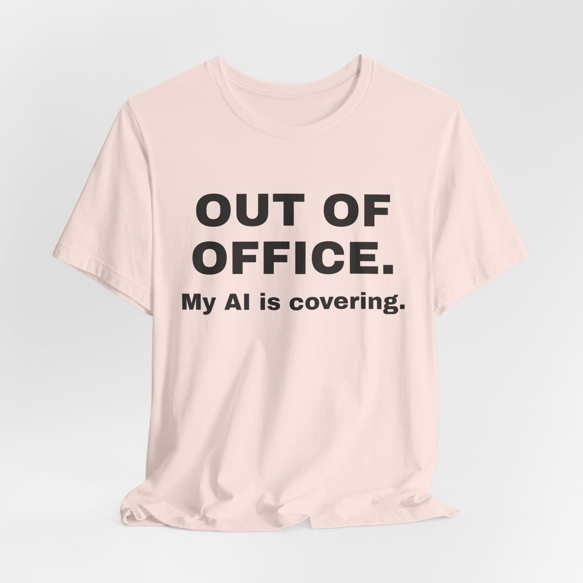 Soft pink t-shirt printed with 'Out of office. My AI is covering.'