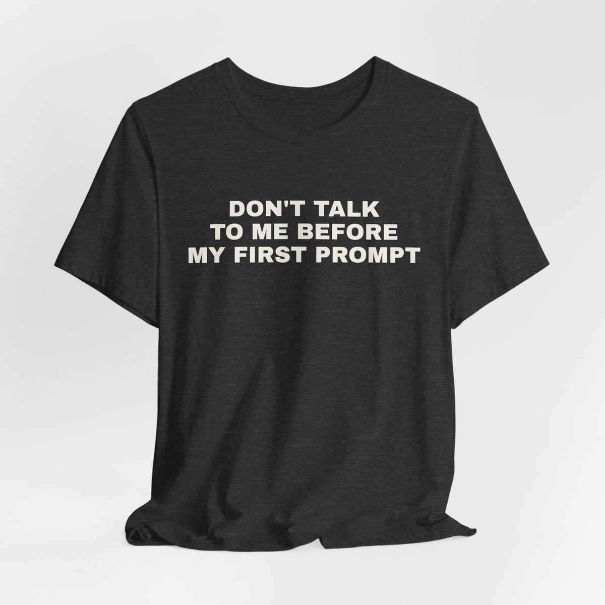 Dark grey heather t-shirt printed with 'Don't talk to me before my first prompt'