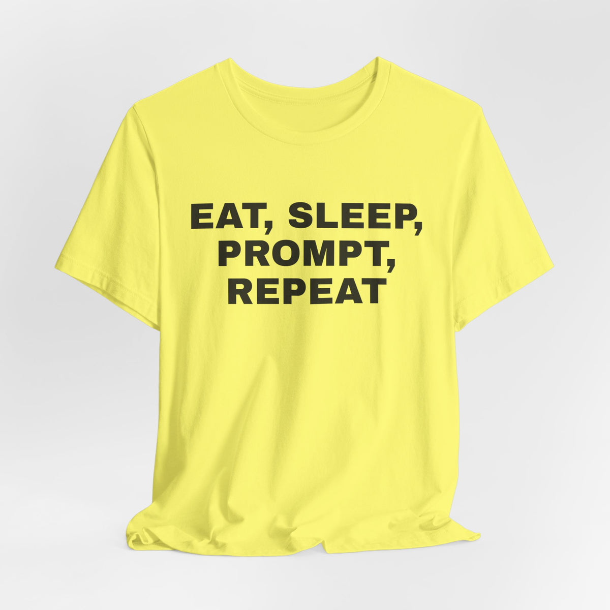 Yellow t-shirt printed with 'Eat, sleep, prompt, repeat'