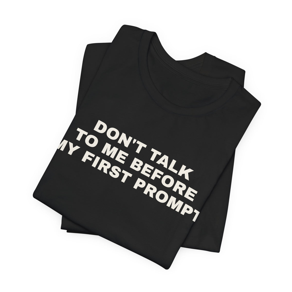 Black t-shirt printed with 'Don't talk to me before my first prompt', folded