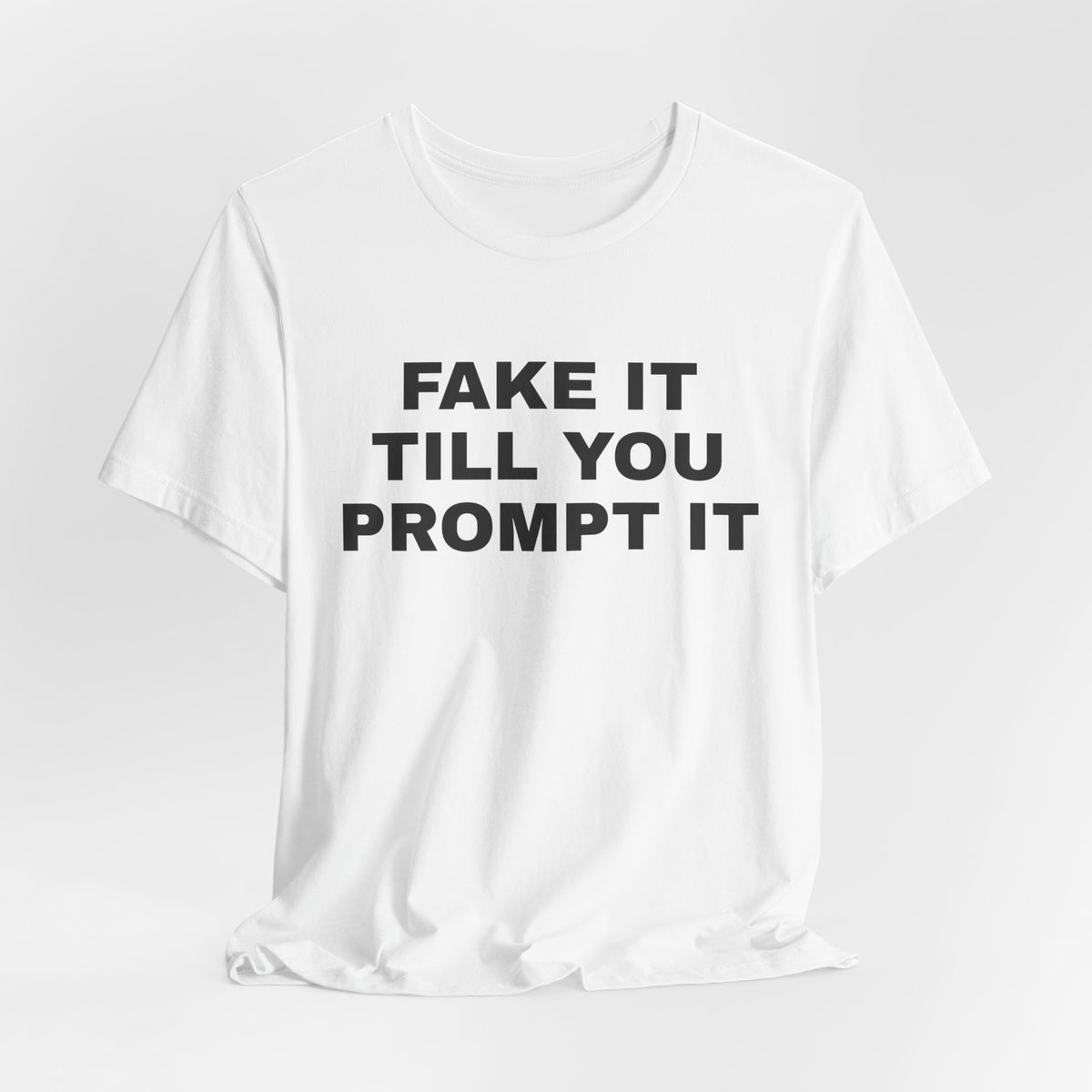 White t-shirt printed with 'Fake it till you prompt it'