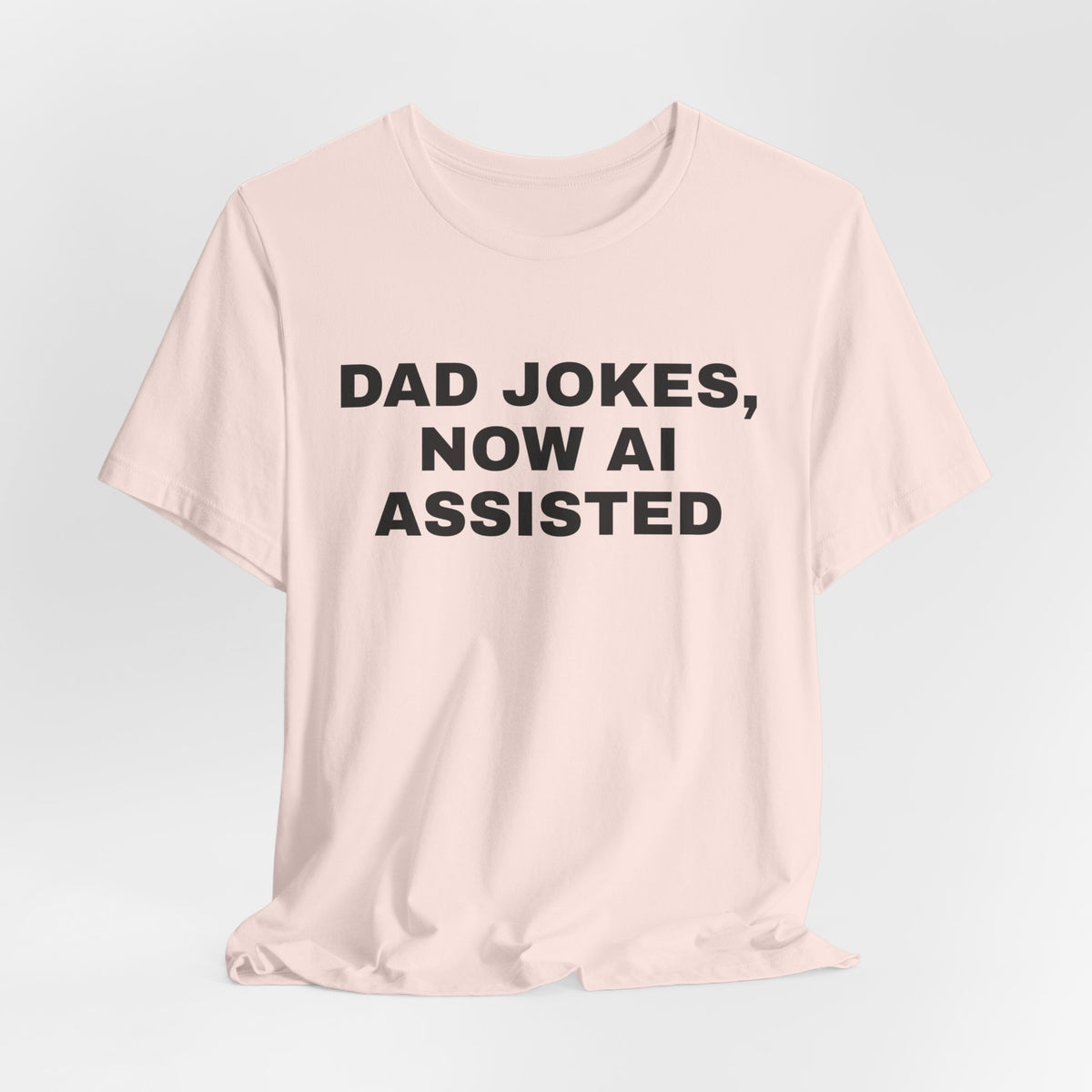 Soft pink t-shirt printed with 'Dad jokes, now AI assisted'