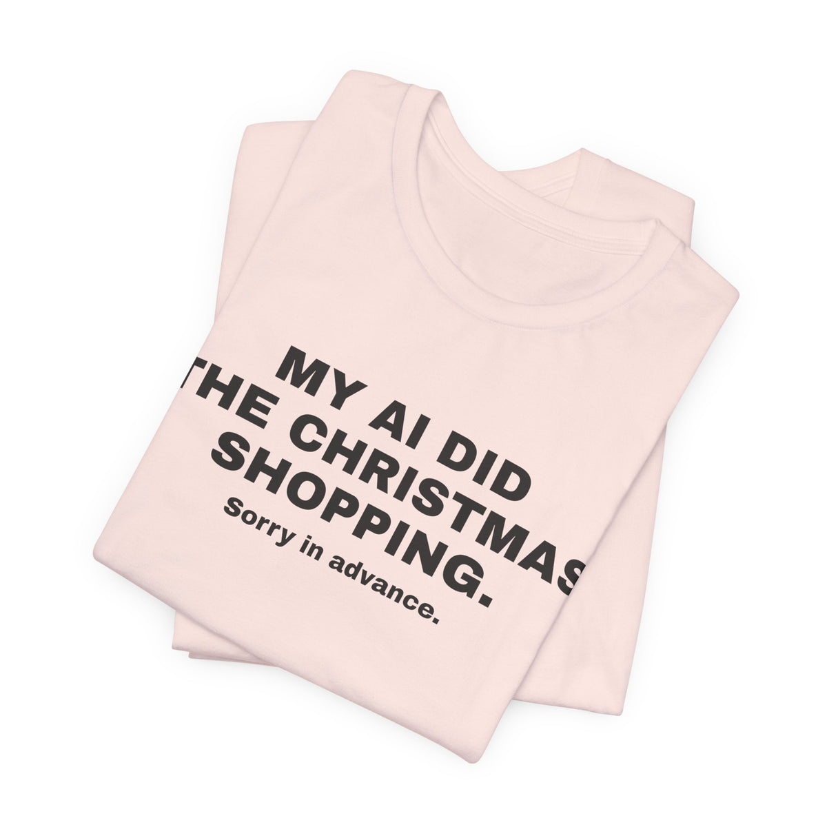 Soft pink t-shirt printed with 'My AI Did the Christmas Shopping. Sorry in Advance.', folded