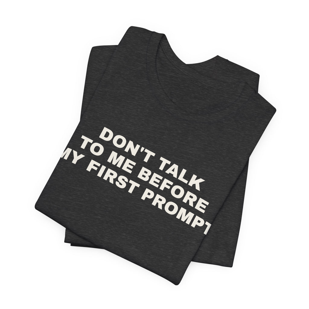 Dark grey heather t-shirt printed with 'Don't talk to me before my first prompt', folded