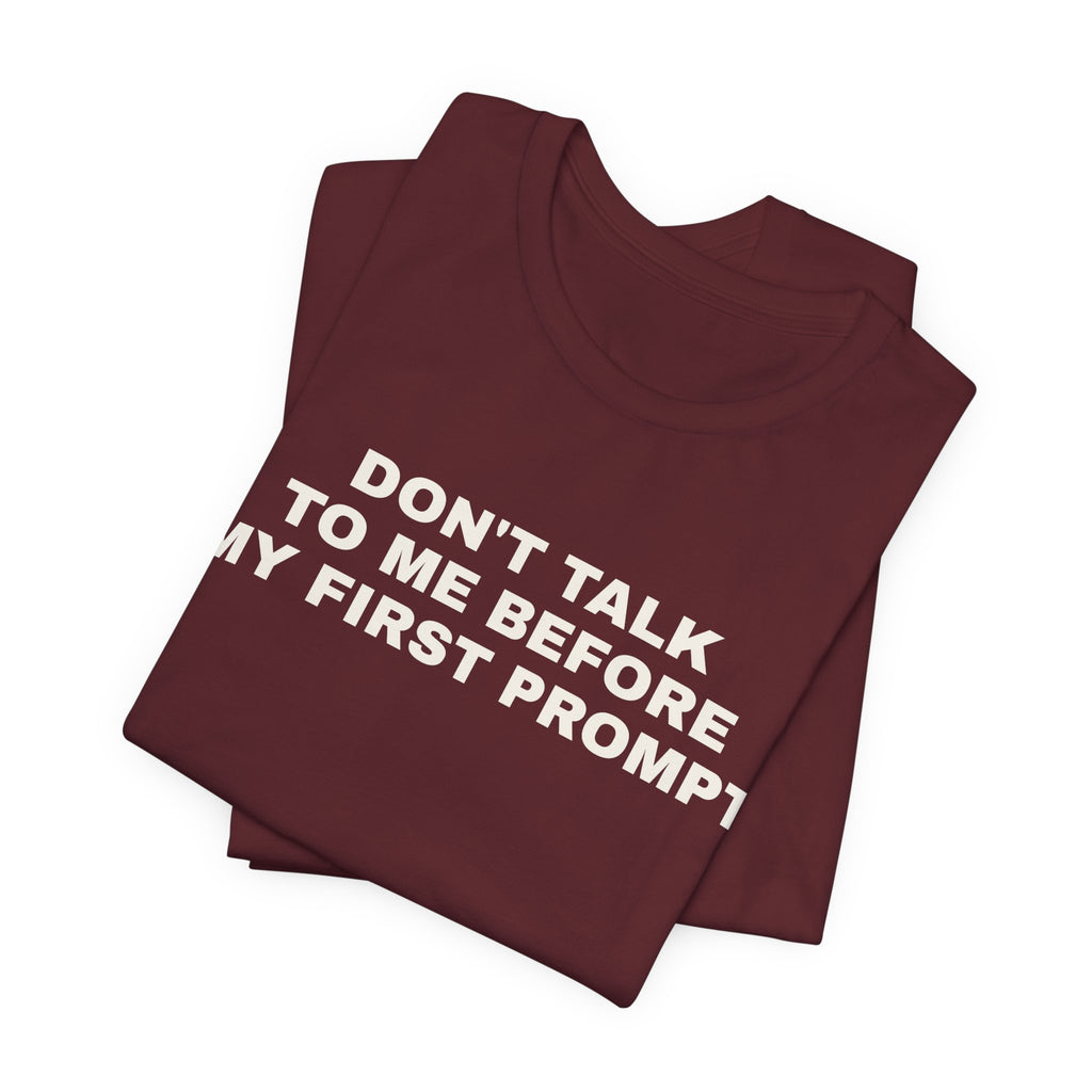 Maroon t-shirt printed with 'Don't talk to me before my first prompt', folded