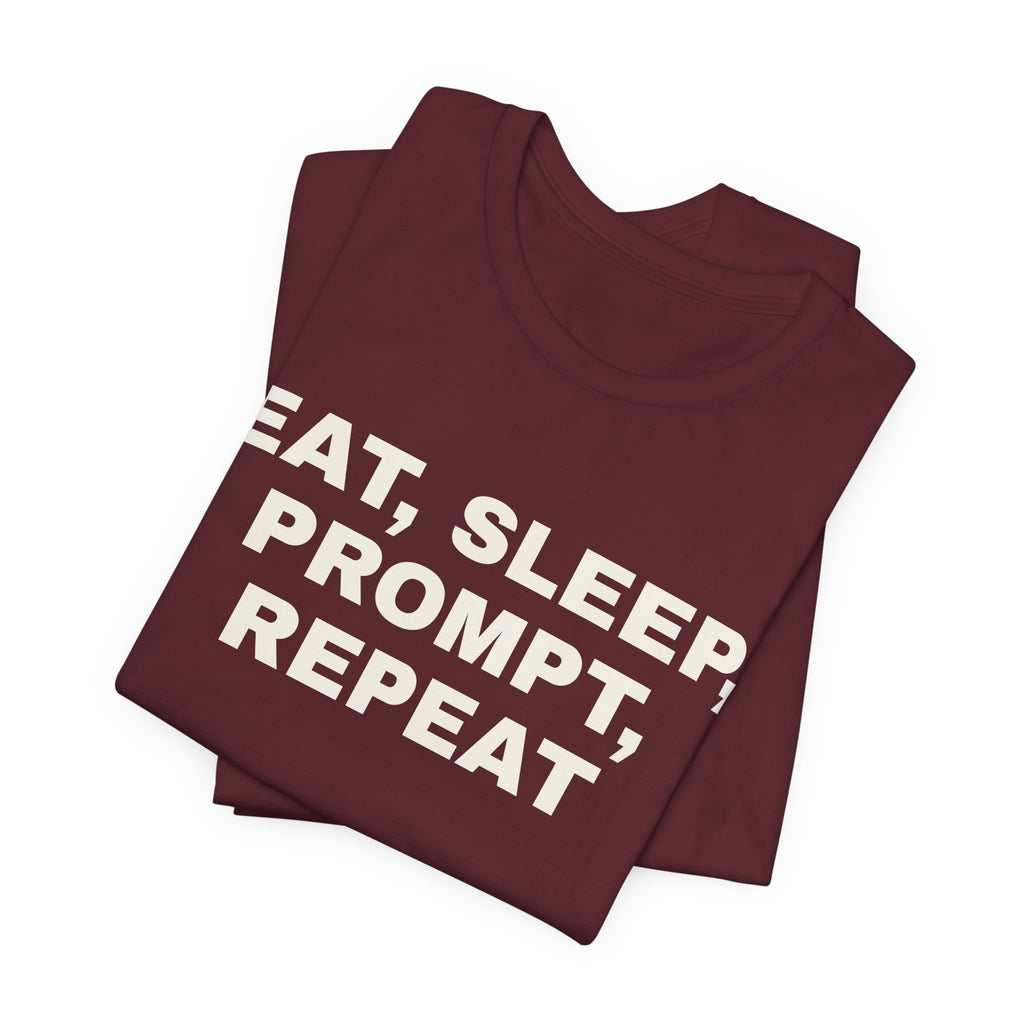 Maroon t-shirt printed with 'Eat, sleep, prompt, repeat', folded