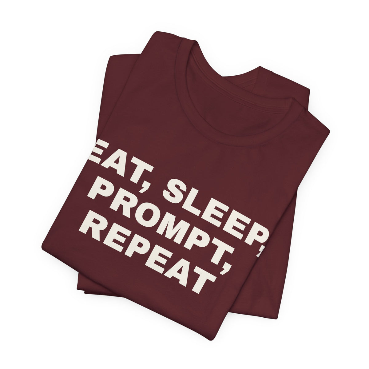 Maroon t-shirt printed with 'Eat, sleep, prompt, repeat', folded