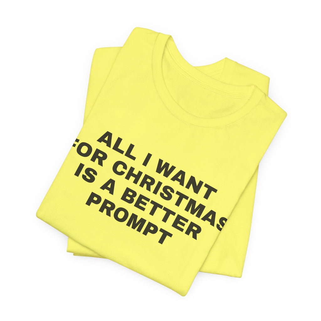 Yellow t-shirt printed with 'All I want for Christmas is a better prompt', folded