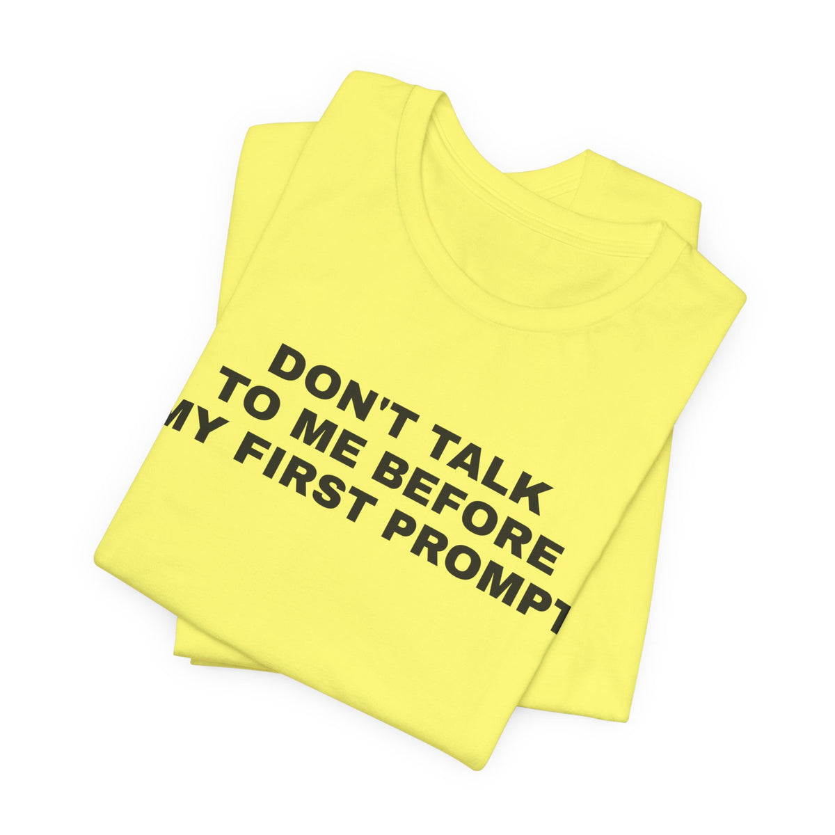 Yellow t-shirt printed with 'Don't talk to me before my first prompt', folded