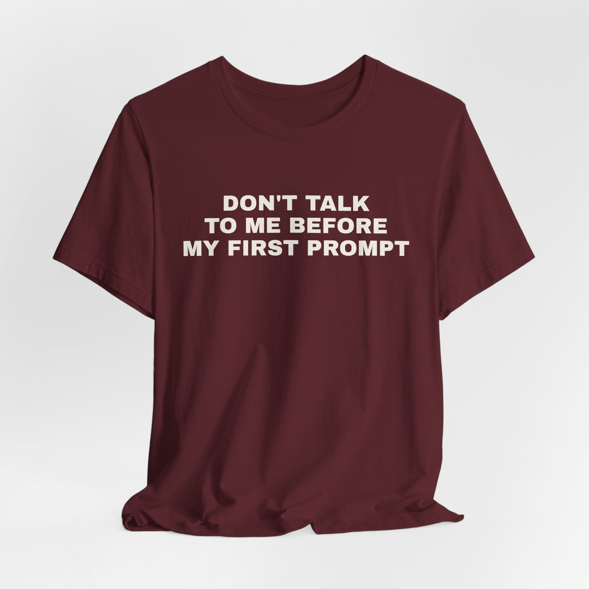 Maroon t-shirt printed with 'Don't talk to me before my first prompt'