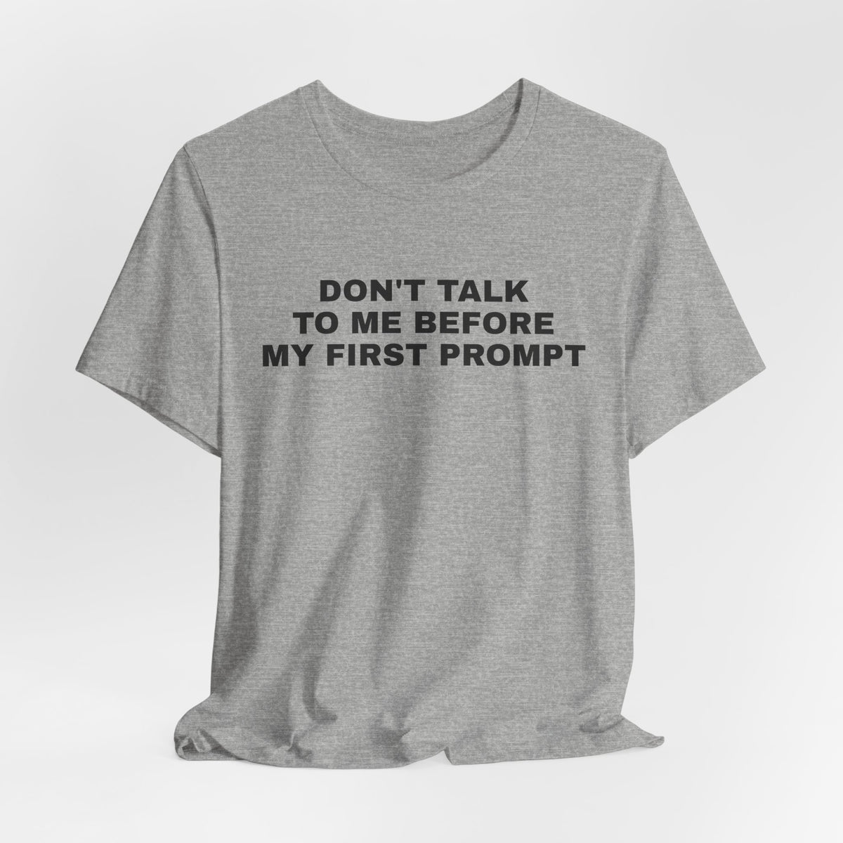 Athletic heather t-shirt printed with 'Don't talk to me before my first prompt'